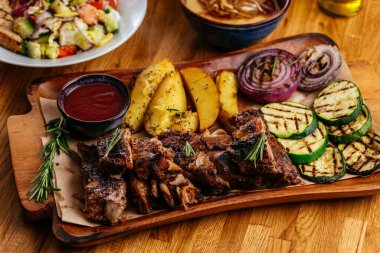 Ahşap masada sebzeli ızgara tavuk.