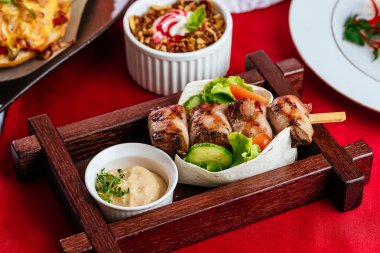 Ahşap masada sebzeli ızgara tavuk.