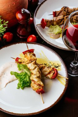 Ahşap masada sebzeli ızgara tavuk.