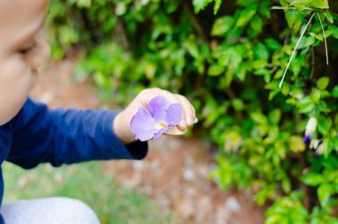 Mor çiçekli melez bir gencin portresi.