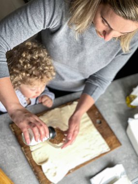 Anne ve oğlu tarçınlı çörek yapıyor.
