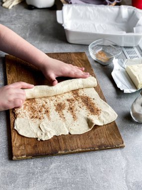 Çocuk elleriyle hamuru yuvarlıyor.