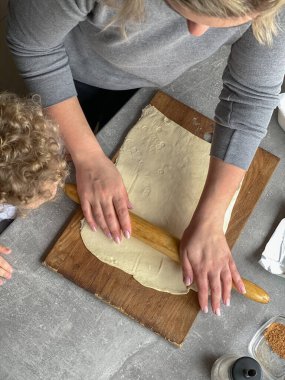 Anne ve oğlu hamurdan çörek yapıyor.