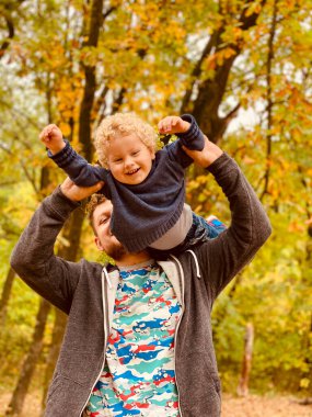 Baba oğluyla parkta oynuyor.