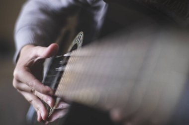 Bir çocuk akustik gitar çalıyor.