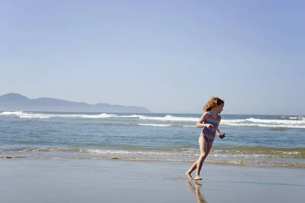 Щаслива Маленька Руда Дівчинка Біжить Уздовж Берега Океану — стокове фото