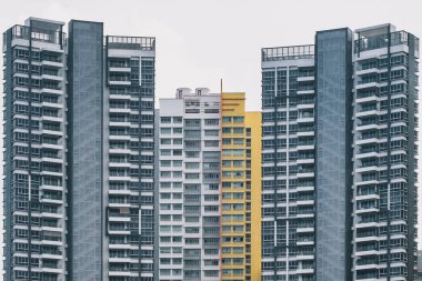 Singapur 'da yağmur yağarken kasvetli tonları olan eski, yoğun bir apartman kompleksinin ön görüntüsü