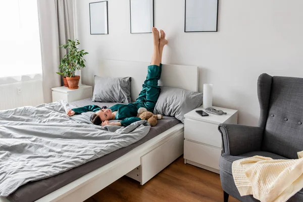 Молода Жінка Шовковій Піжамі Лежить Догори Ногами Ліжку Спальні — стокове фото