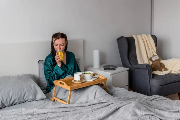 Jonge Vrouw Zijde Pyjama Eet Haar Ontbijt Drinkt Vers Geperst — Stockfoto