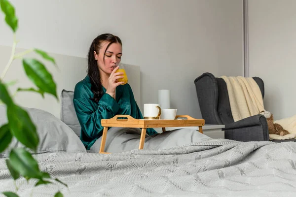 Jonge Vrouw Zijden Pyjama Eet Haar Ontbijt Terwijl Bed Ligt — Stockfoto