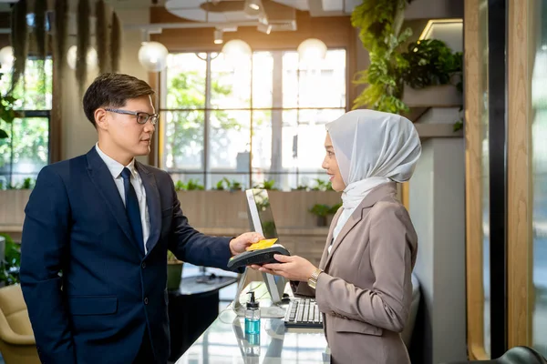 Business people pay by credit card,Businessman using credit card for payment to receptionist at restaurant, cashless technology and credit card payment concept.
