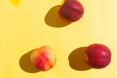 Sarı arka planda üç parça şeftali.