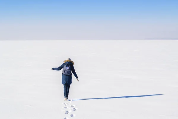 穿着蓝色外套在雪地上行走的女人 — 图库照片
