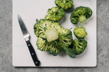 Daha büyük bir taçtan kesilmiş brokoli çiçeklerinin resmi.