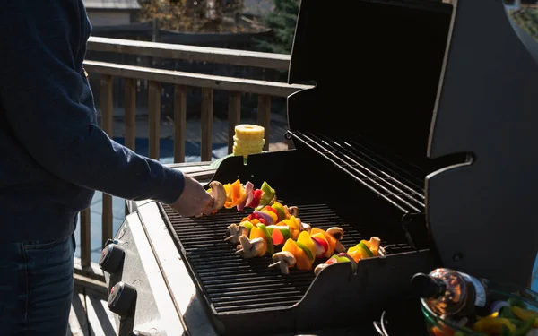 Uomo Mettendo Spiedini Vegetali Una Griglia Barbecue Gas All Aperto — Foto Stock