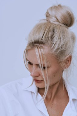 Beyaz duvarda güzel, genç, gülümseyen, zeki, sarışın çilli bir kadın. Başla.