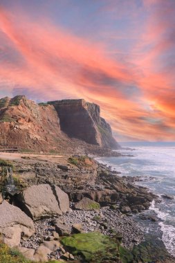 Atlantik kıyısında gün batımında inanılmaz bir uçurum. Por 'da Deniz Burnu