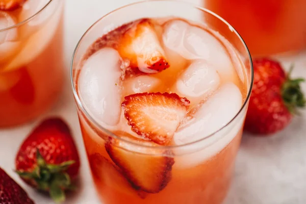 Glass of strawberry lemonade with sliced strawberries
