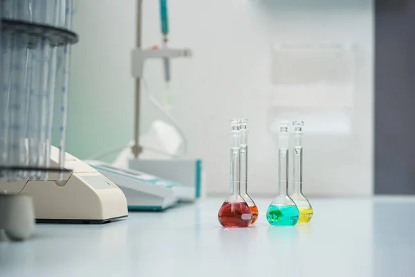 化学実験室のテーブルの上に試験管と試験液でフラスコ — ストック写真