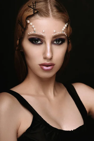 Beautiful woman portrait with art make up, pearl beads on face.