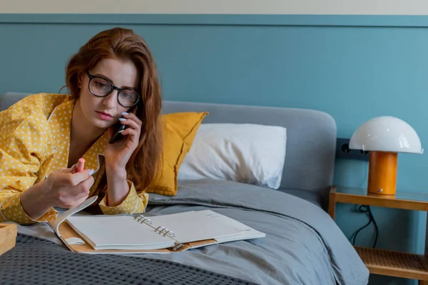 Young Woman Comfortable Yellow Pajamas Works Talks Cell Phone While — Stock Photo, Image