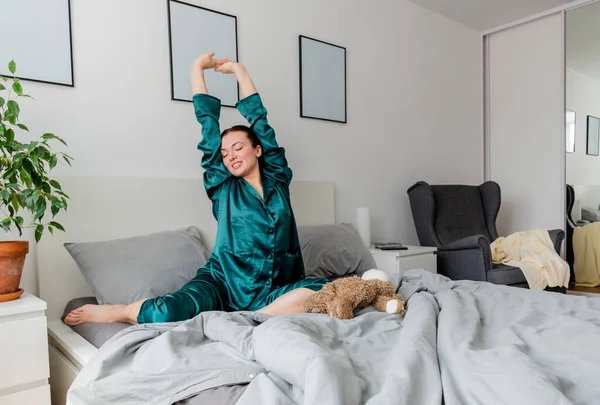 Jonge Vrouw Zijde Pyjama Geeuwt Terwijl Zitten Comfortabele Zachte Bed — Stockfoto