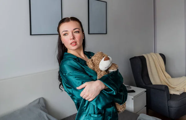 Jonge Vrouw Zijden Pyjama Zit Het Bed Knuffelt Een Teddybeer — Stockfoto