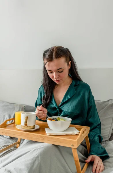 Jonge Vrouw Zijden Pyjama Eet Haar Ontbijt Terwijl Bed Ligt — Stockfoto