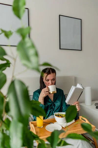 Jonge Vrouw Zijden Pyjama Heeft Een Gezond Ontbijt Lees Boek — Stockfoto