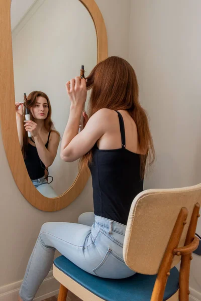 Young Red Haired Woman Sits Chair Front Mirror Doing Her — Stock Photo, Image