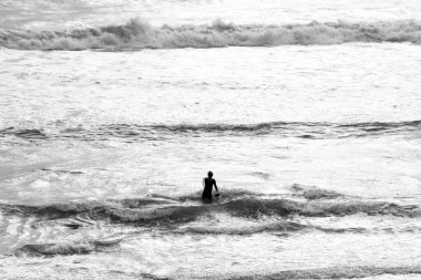 Sörf yapmak için denize giren bir adam.
