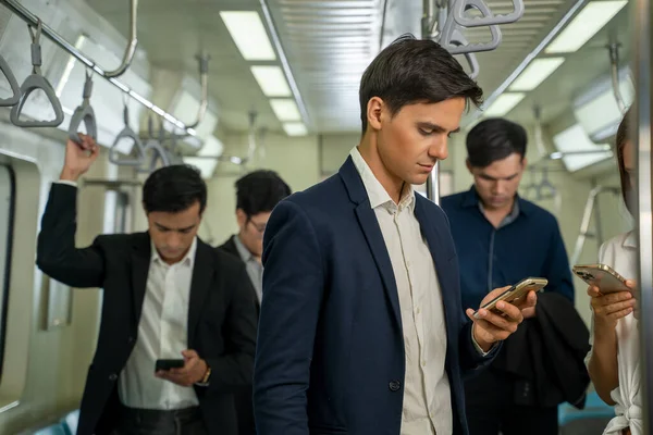 Business people and office worker with smartphone in subway