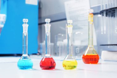 Test tüpleri ve deney tüpleri kimya laboratuarındaki masada üzerinde test sıvısı olan şişeler.