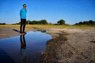 Gülümseyen genç adam suya yansıdı.