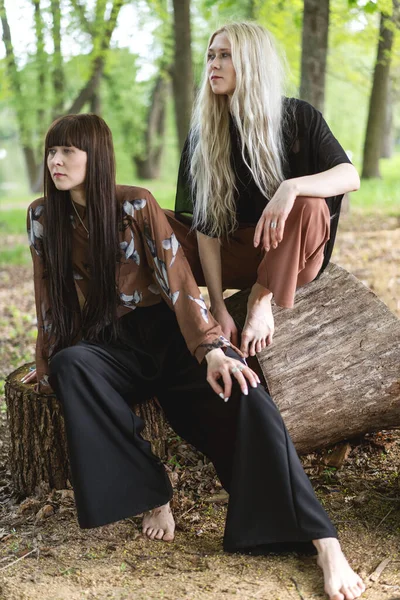 stock image fashion twin girls posing against the background of a wooden lan