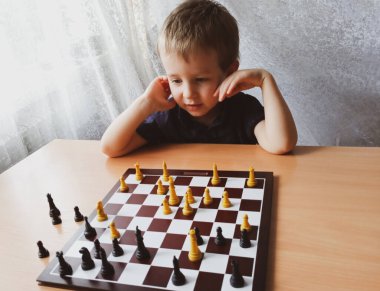 Küçük çocuk evde satranç oynarken düşünür. Boş zaman