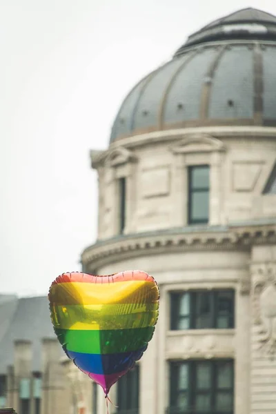 Ein Herzförmiger Regenbogenballon Schwebt Vor Einem Gebäude — Stockfoto