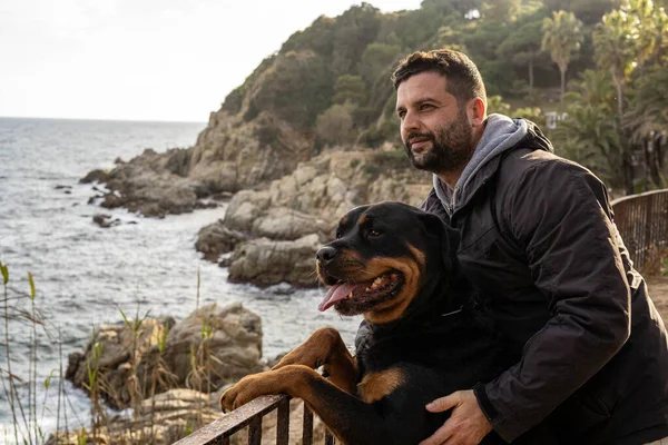 Uomo Godendo Vista Sul Mare Con Suo Cane Rottweiler — Foto Stock