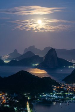 Okyanus, dağlar ve gökyüzünde parlak dolunay ile güzel bir mavi saat gün doğumu, Rio de Janeiro, Brezilya