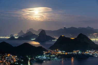 Okyanus, dağlar ve gökyüzünde parlak dolunay ile güzel bir mavi saat gün doğumu, Rio de Janeiro, Brezilya