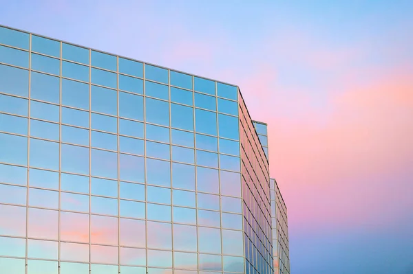 Glass building under pink and blue sky