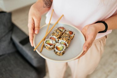 Aile parlak bir dairede öğle yemeği yiyor suşi yiyor. Masa oyunları oynuyorlar..
