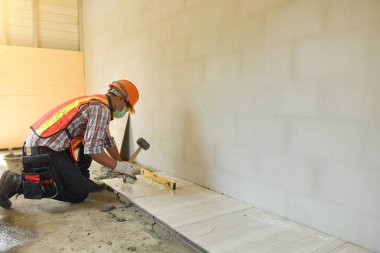 Worker laying ceramic tiles. Home tile improvement