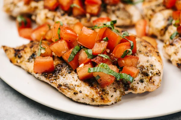 stock image Closeup of grilled seasoned chicken breast topped with tomatoes