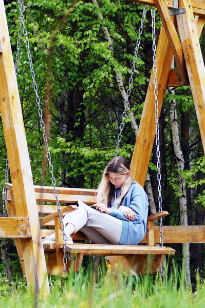 Egy Tinédzser Lány Könyvet Olvas Hintán Ülve — Stock Fotó
