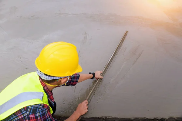 Worker Aligning Frsh Cement Construction Filed — Zdjęcie stockowe