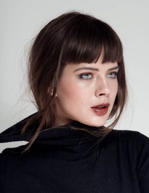 Bayan portresi. Temiz ciltli güzel bir spa mankeni kız. Kabarık kaşlar. Gençlik ve cilt bakımı konsepti. Beyaz arka plan. Akşam makyajı, yaldızlı kumaş, boğucu g