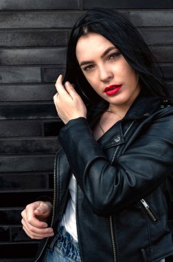 Bir binanın arka planında genç bir kadının portresi.