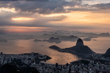 Rio de Janeiro, Brezilya 'da renkli gündoğumu bulutlarıyla şehre, dağlara ve okyanusa güzel bir manzara