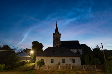 Slovakya 'nın Turciansky Dur köyündeki Gotik bir kilisenin üzerindeki gece bulutları
